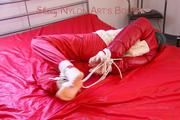 Mara tied, gagged and hooded on bed wearing a shiny red old school down jacket and pants (Pics)