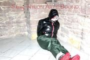 Jill tied, gagged and hooded on a cellar floor wearing a shiny green rain pants and a shiny black down jacket (Pics)