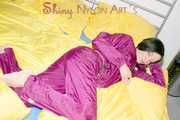 ENNI wearing a sexy purple shiny nylon rain suit lying in bed with yellow shiny nylon cloths lolling and posing (Pics)