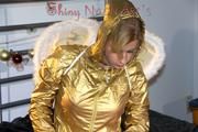 Pia posing in bed wearing golden shiny nylon rainwear and wings (Pics)
