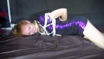 Red haired Woman bound and gagged in a shiny purple wetlook Dress