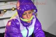 Pia wearing a pink rain pants and a purple down jacket tied with cuffs and gagged on bed (Pics) 