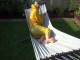 Watch Chloe enjoying the warm Sun in her yellow shiny nylon Rainsuit 