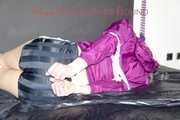 Pia tied and gagged on a bed with belts wearing a sexy black shiny nylon shorts and a purple shiny nylon rain jacket (Pics)