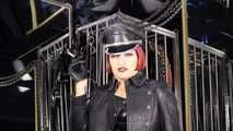 Mistress Tokyo smoking cigarette in leather, gloves and Muir Cap; fetish, POV