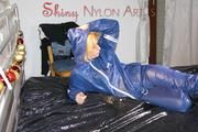 Pia wearing a sexy oldschool shiny nylon AGU rainwear combination posing and lolling on bed (Pics)