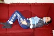 Lucy wearing a blue shiny nylon pants and an oldschool blue rain jacket tied and gagged with ropes on a sofa (Pics)