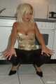 Natural busty Martina posing in a golden corsage, black leggins, pantyhose and heels in the kitchen
