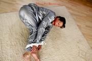 Alina tied and gagged in a shiny silver PVC saunasuit