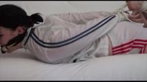 Jill tied and gagged on a white sofa wearing a white nylon shorts and a white rain jacket (Video)