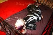 Mara tied with tape and gagged on a princess bed in an old cellar wearing an black sauna suit (Pics)