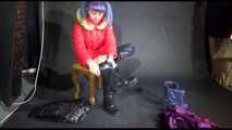 Mara wearing sexy purple rainwear trying on a black down pants and a red down jacket infront of the camera (Video)