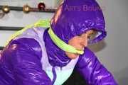 Pia wearing a pink rain pants and a purple down jacket tied with cuffs and gagged on bed (Pics) 