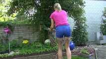 Watch Maly in her shiny nylon Shorts enjoying the warm Weather in the Garden