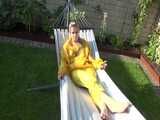 Watch Chloe enjoying the warm Sun in her yellow shiny nylon Rainsuit 