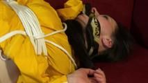 Lucy tied and gagged on a red sofa wearing a sexy yellow shiny nylon shorts and a yellow rain jacket (Video)