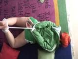 Jill tied and gagged on the floor in a green shiny nylon shorts and an green rain jacket (Video)