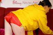 Lucy wearing a sexy red shiny nylon shorts and a yellow rain jacket preparing the sofa to lay down (Pics)