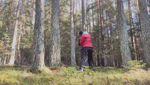 Sebastien breathplay tied up in a puffer jacket among the trees.