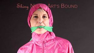 Mara during a cloth bondage photoshooting in a studio wearing a sexy pink rainwear combination and rubber boots (Pics)