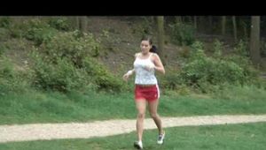 Enni jogs wearing red shiny nylon shorts and a top (Video)