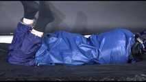 Lucy ties and gagges herself with cuffs on a bed wearing sexy blue shiny nylon rainwear (Video)