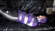 SANDRA tied and gagged with tape on a sofa wearing a sexy black shiny nylon pants and a purple rain jacket (Video)