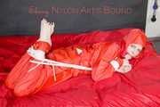 Destiny wearing a sexy red rain suit tied and gagged and hooded with ropes and a cloth gag on a bed (Pics)