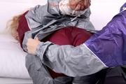 Sophie tied and gagged by Jill on a sofa wearing a shiny silver PVC sauna suit which is slitted by Jill (Pics)