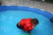 Watch Sandra taking a bath at a hot Summer Day with her shiny nylon Downjacket using the Jacket as a snorkel (special wish for a friend)