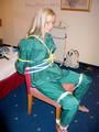 Blonde archive girl tied and gagged in an green shiny nylon rainsuit on a chair (Pics)