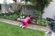 Watching Aiyana wearing supersexy pink shiny nylon rainwear while planting flowers in the garden (Pics)