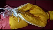 Lucy tied, gagged and hooded on a red sofa wearing a sexy orange shiny nylon pants and a yellow rain jacket (Video)