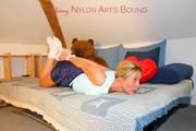 Blonde archive girl tied and gagged on bed wearing a darkblue shiny nylon shorts (Pics)