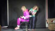 Sexy Pia tied and gagged with ropes and a clothgag on a hairdresser´s chair wearing a sexy pink shiny nylon downsuit (Video)