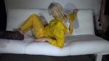 Watching Pia preparing her sofa with a shiny nylon cloth wearing a yellow shiny nylon rainsuit enjoying herslef on the sofa (Video)