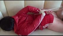 Jill tied, gagged and hooded on a white sofa wearing a sexy shiny red nylon shorts and a red rainjacket (Video)