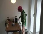 Marlin in the kitchen preparing a coffee wearing a green shiny nylon shorts and a green rain jacket (Video)