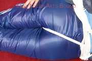 Lucy wearing a blue shiny nylon pants and an oldschool blue rain jacket tied and gagged with ropes on a sofa (Pics)