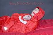 Destiny wearing a sexy red rain suit tied and gagged and hooded with ropes and a cloth gag on a bed (Pics)