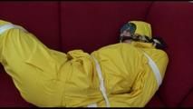 Mara tied and gagged with tape on a sofa wearing a sexy shiny yellow rainwear combination (Video)