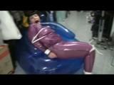 Video with Jill tied and gagged in a shiny purple semi transparent PVC suit