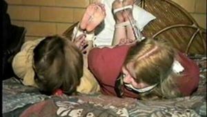 TUBE, BALL, CLEAVE, WRISTS GAGGED & HOG-TIED CARRIE & DEB (D18-2)