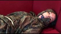 Jill tied, gagged and hooded on a red sofa wearing sexy shiny nylon camouflage rainwear (Video)