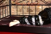 Mara tied with tape and gagged on a princess bed in an old cellar wearing an black sauna suit (Pics)