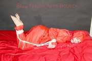Destiny wearing a sexy red rain suit tied and gagged and hooded with ropes and a cloth gag on a bed (Pics)