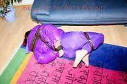 Jill tied and gagged with webbing load restraint assembly on the floor wearing a sexy purple down jacket and a rain pants (Pics)