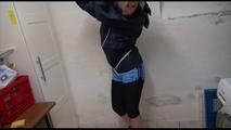 Pia tied and gagged over head in a laundry wearing a supersexy black leggins and a blue shiny nylon adidas shorts as well as a blue rain jacket (Video) 