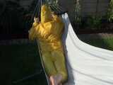 Watch Chloe enjoying the warm Sun in her yellow shiny nylon Rainsuit 