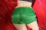 Sexy Sonja wearing a hot green shiny nylon shorts and a black rain jacket posing infront of the camera and lolling on bed (Pics)